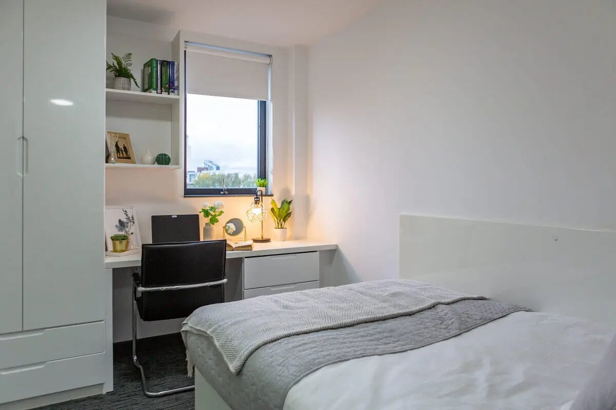 Wardrobe desk chair bed with gray blanket bedroom at Glassworks - Liverpool in Liverpool Student Accommodation