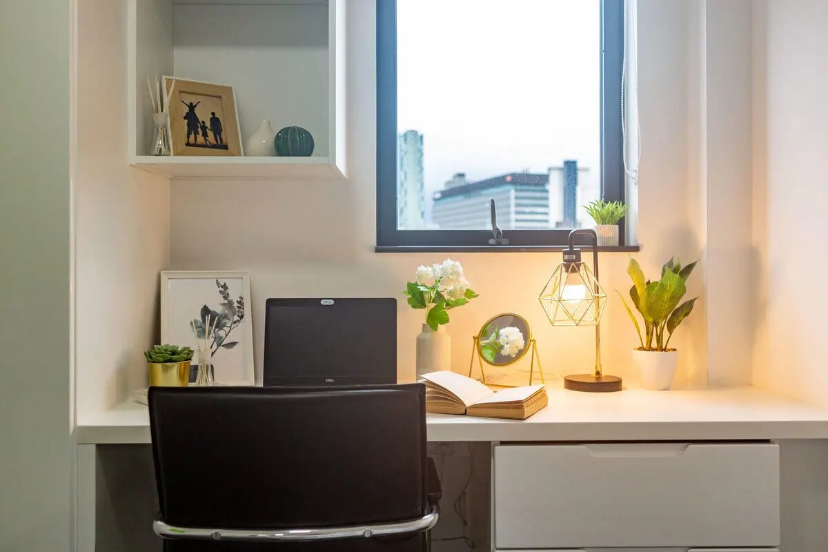 Desk with laptop plants mirror lamp and book study area at Glassworks - Liverpool in Liverpool Student Accommodation