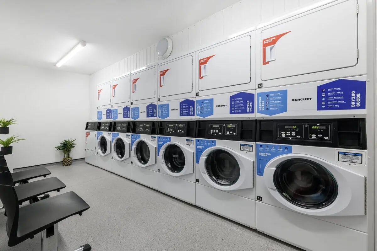 Laundry machines and chairs common room at Glassworks - Liverpool in Liverpool Student Accommodation
