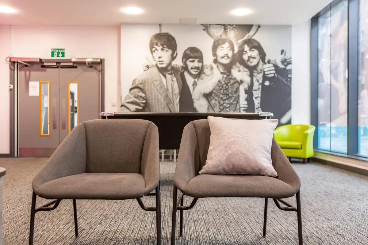 Two chairs Beatles mural green armchair lounge area at Glassworks - Liverpool in Liverpool Student Accommodation
