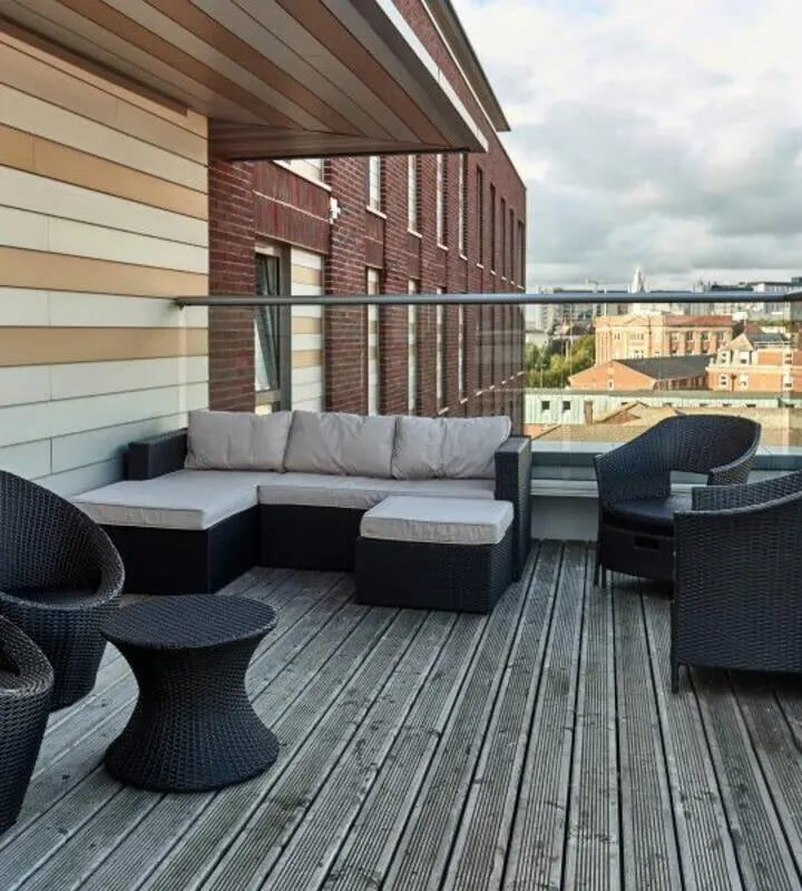 Outdoor lounge furniture on a balcony with cityscape balcony area at Hope Street in Liverpool Student Accommodation