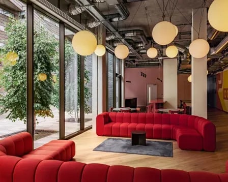 Red sectional sofa with low tables living room at Scape Mile End in London Student Accommodation
