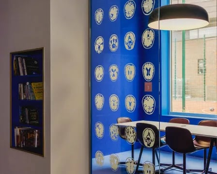 Table chairs and bookshelf with books study area at Scape Mile End in London Student Accommodation