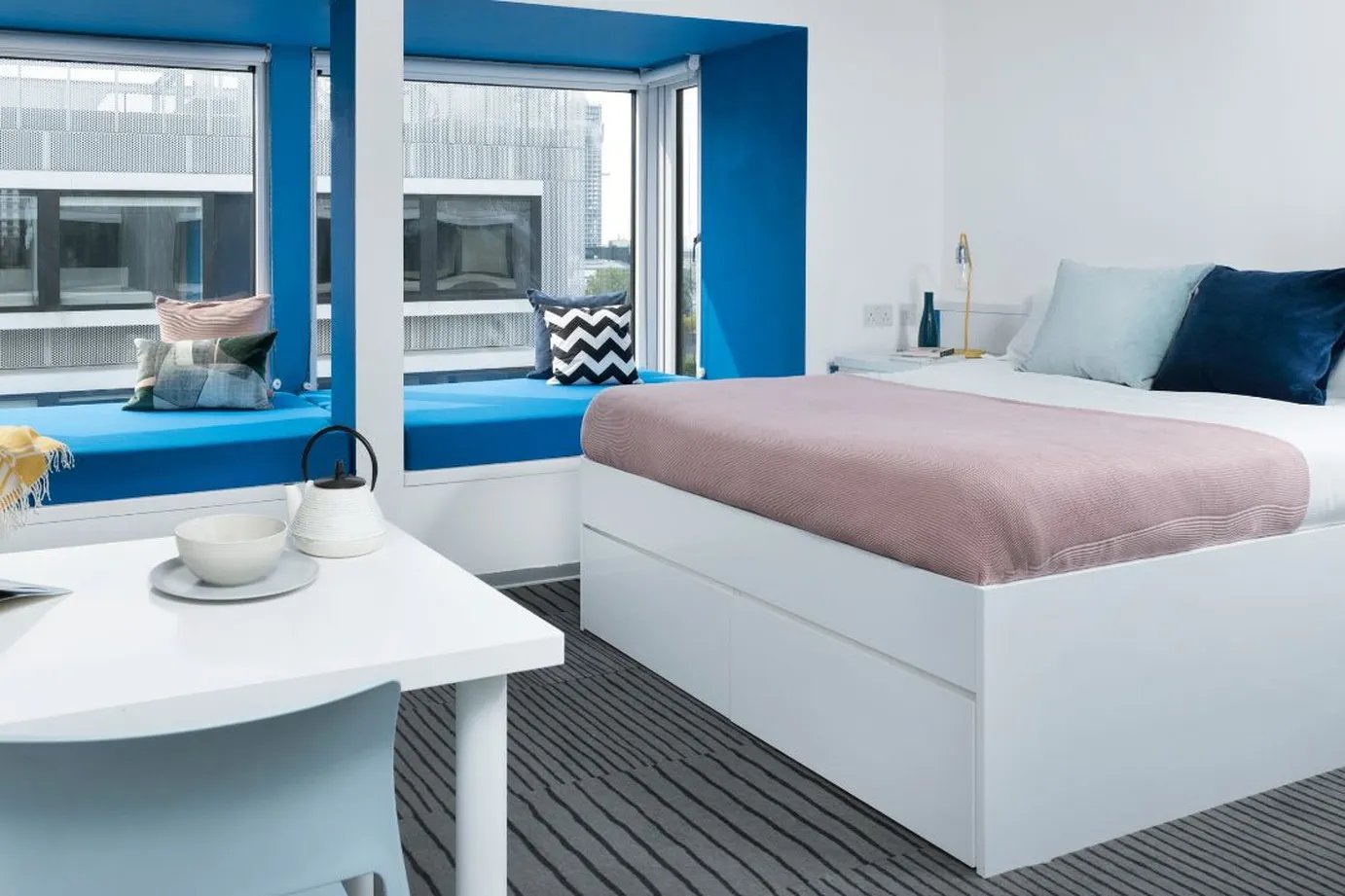 Bed side table with kettle bowl and bed bedroom at Scape Mile End in London Student Accommodation