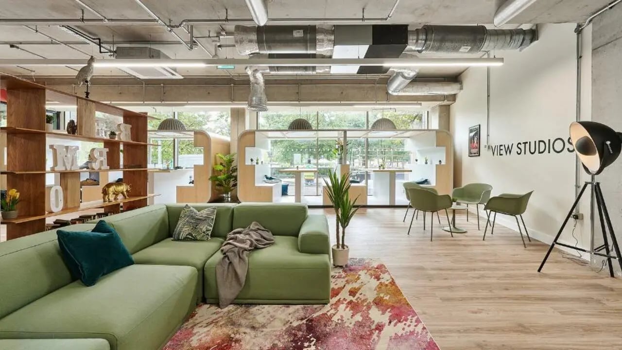 Green sectional sofa artwork and shelving common area at Host View Studios in London Student Accommodation