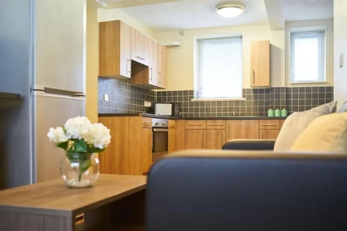 Fridge microwave wooden cabinets tiled backsplash living room at St Andrews Gardens - Liverpool in Liverpool Student Accommodation