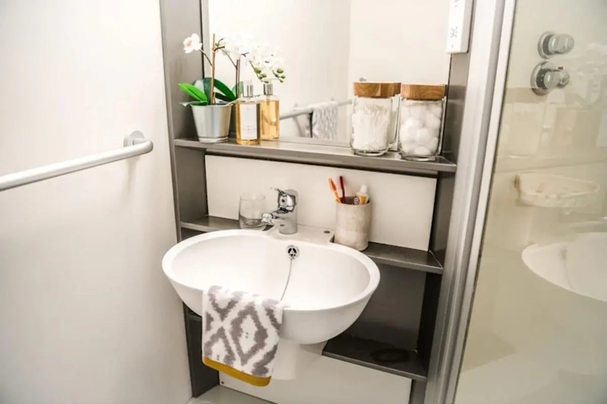 Sink with towel toiletries and shower visible bathroom at McDonald Road in Edinburgh Student Accommodation