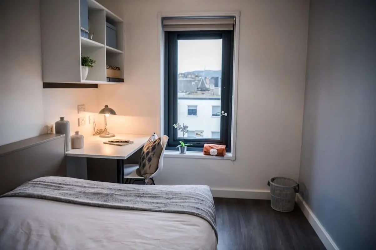 Bed desk shelves lamp chair trash bin bedroom at McDonald Road in Edinburgh Student Accommodation