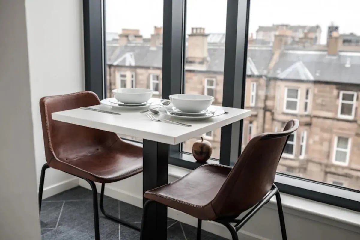 Table with place settings and chairs dining area at McDonald Road in Edinburgh Student Accommodation