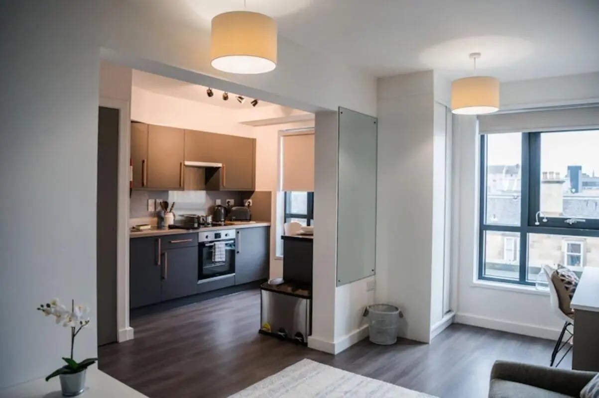 Kitchen counters appliances oven cabinets and window living area at McDonald Road in Edinburgh Student Accommodation