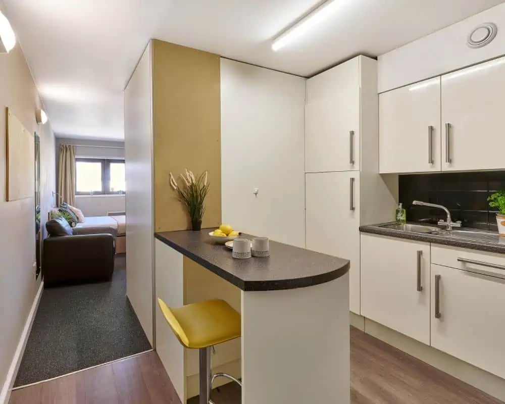 Kitchen counter with stools and bedroom view kitchen at Exeter Trust House in Exeter Student Accommodation
