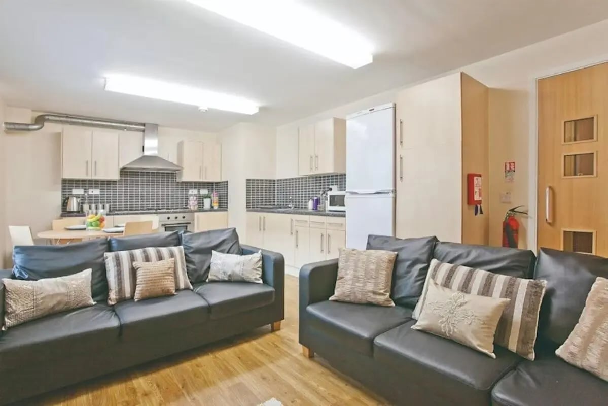 Sofa kitchen cabinets and refrigerator living room at The Glasshouse in Nottingham Student Accommodation