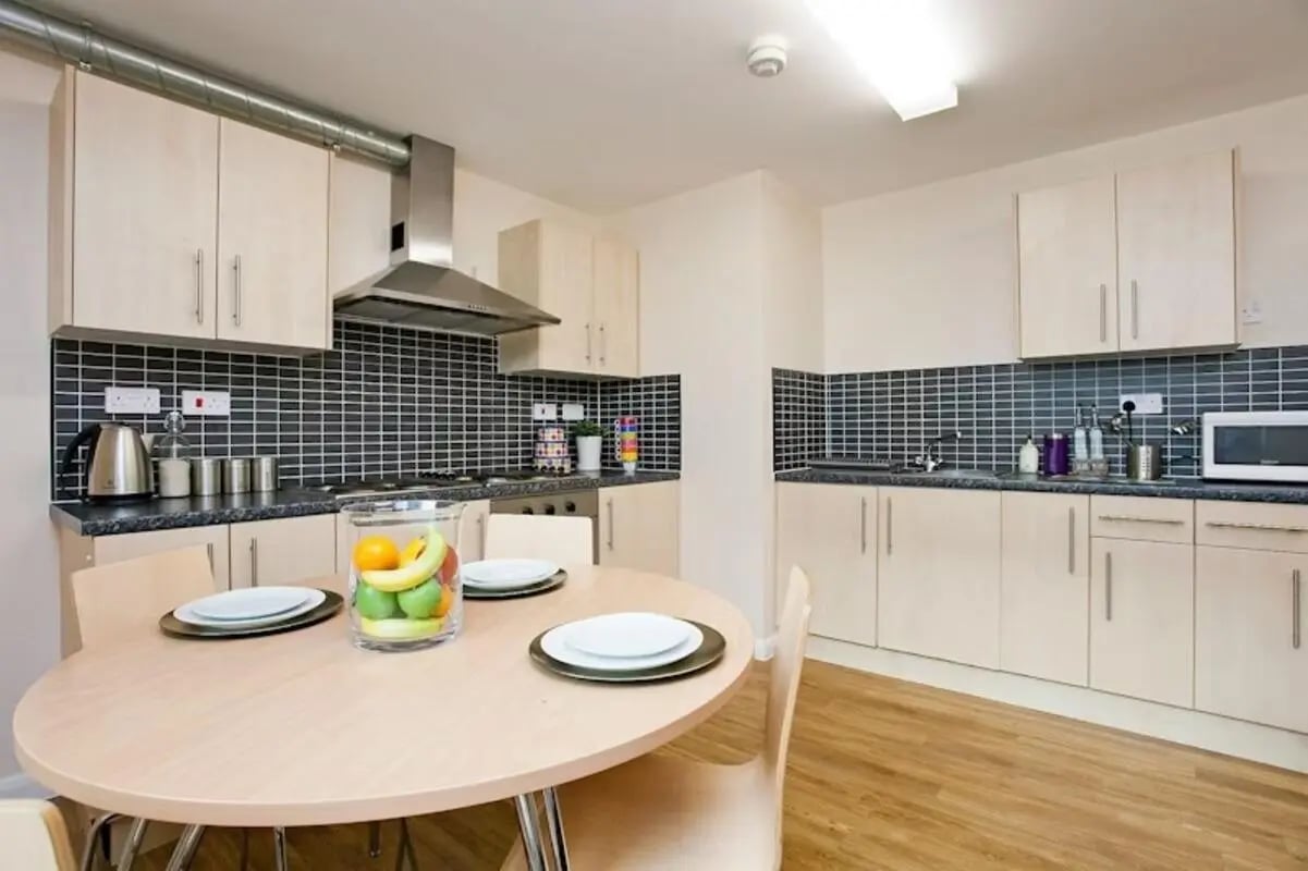 Round table fruit bowl with plates kitchen kitchen at The Glasshouse in Nottingham Student Accommodation