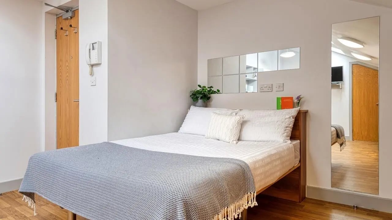 Bed with blue throw and pillows bedroom at Collegiate St James Street in Portsmouth Student Accommodation