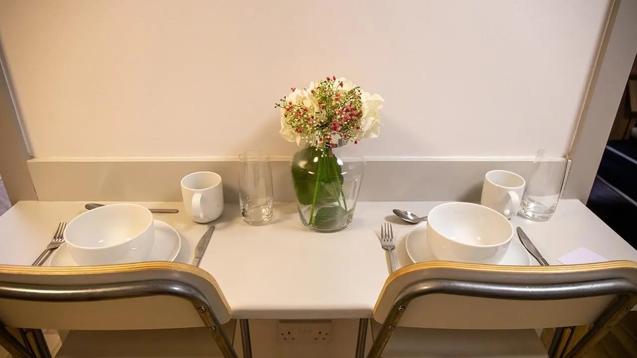 Table setting with flower vase and chairs dining area at Collegiate St James Street in Portsmouth Student Accommodation