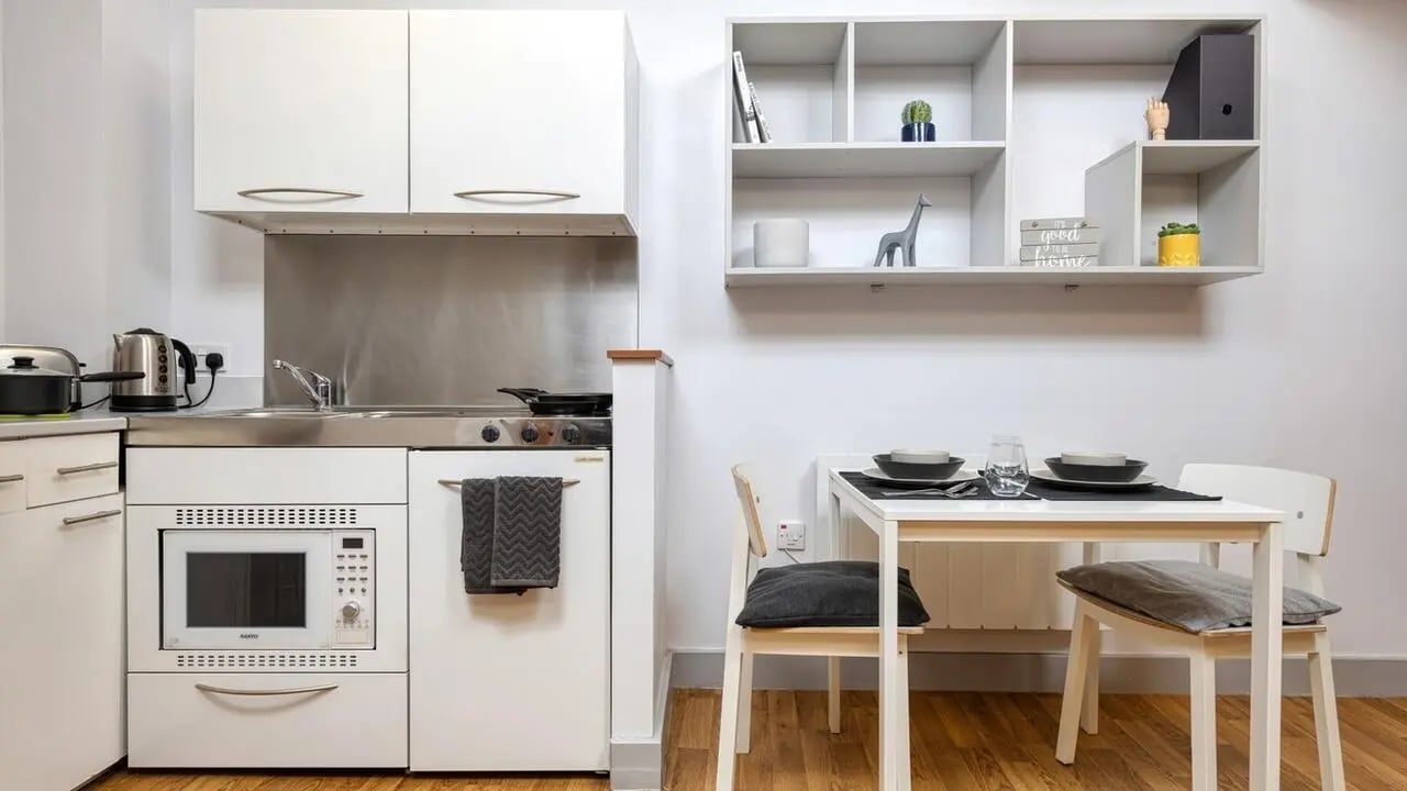 Kitchenette with microwave table and chairs kitchen at Collegiate St James Street in Portsmouth Student Accommodation
