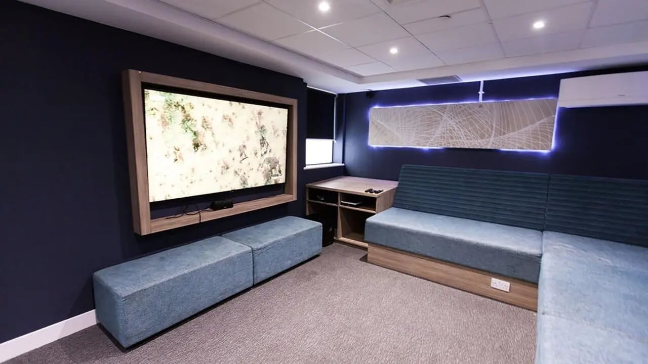 TV blue couches desk and wall art living room at Collegiate Crown Place Portsmouth in Portsmouth Student Accommodation