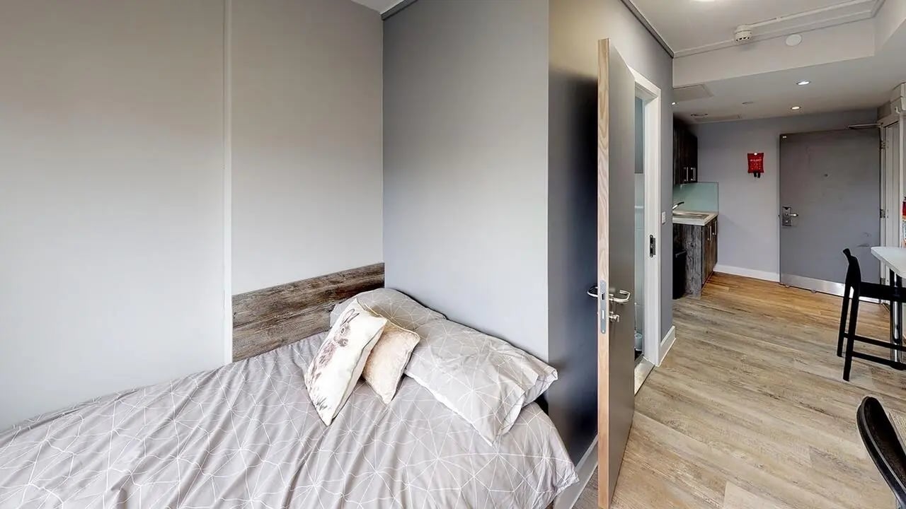 Bed with pillows and patterned duvet studio area at Collegiate Crown Place Portsmouth in Portsmouth Student Accommodation