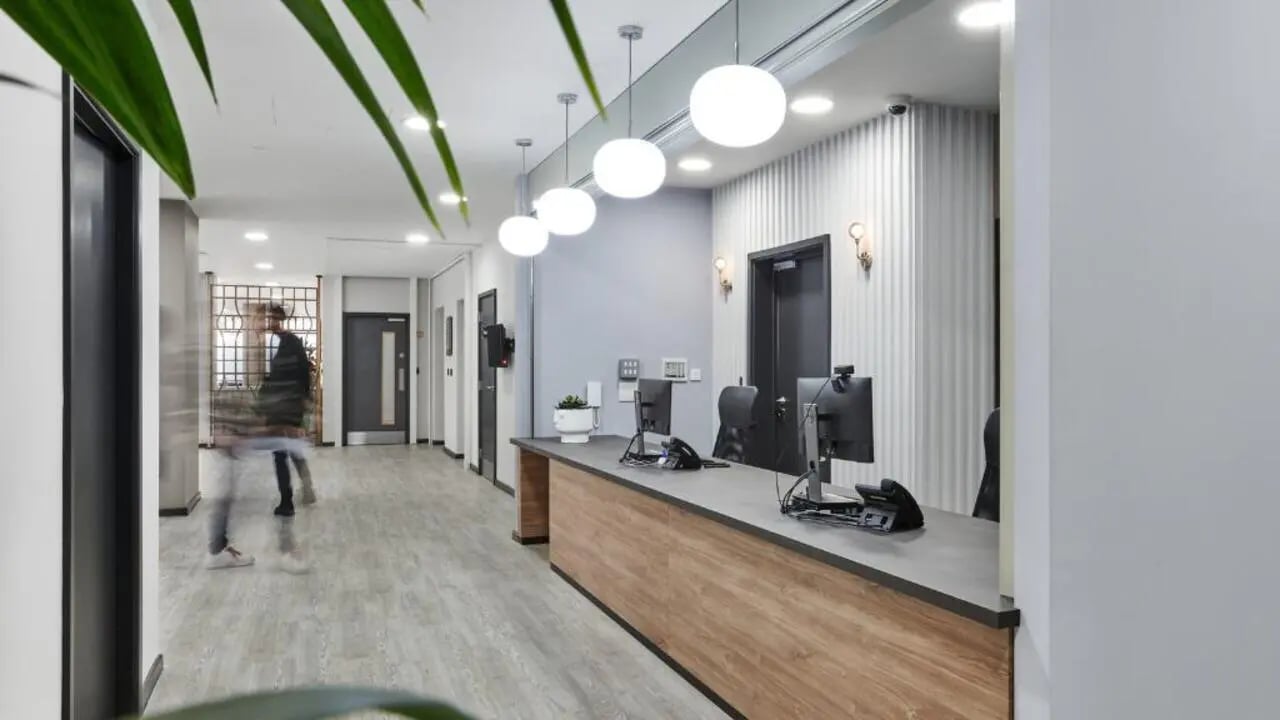 Reception desk with computers and plant exterior at Gosford Gate in Coventry Student Accommodation