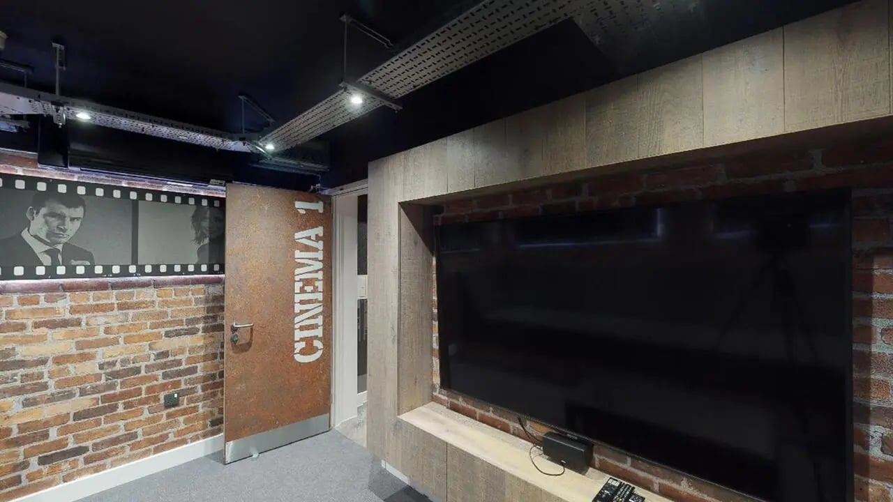 Cinema room with large TV brick walls playing area at Collegiate Crown Place Cardiff in Cardiff Student Accommodation