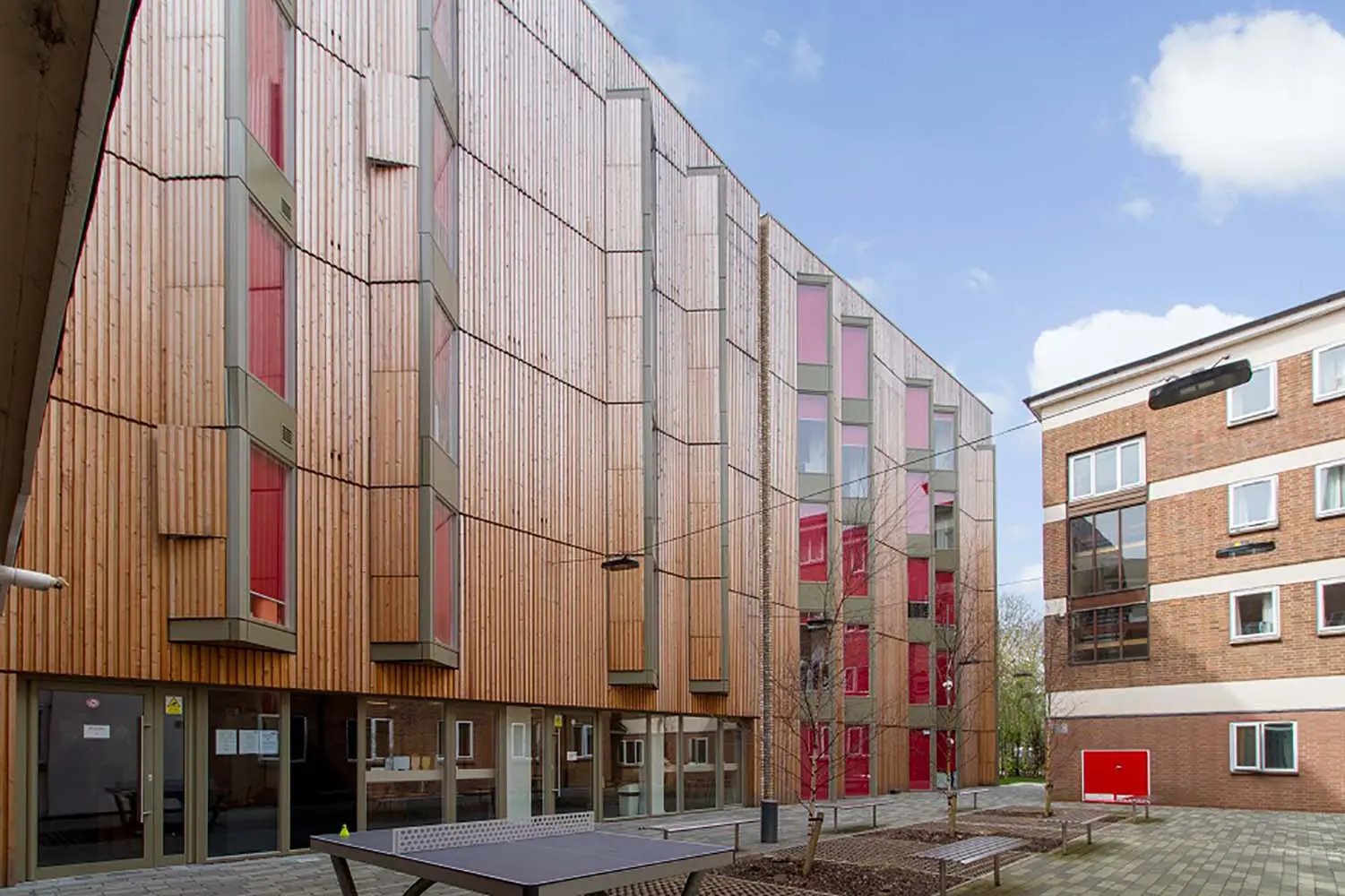 Modern wooden building with red windows exterior at AXO Sherbourne Student Village in Coventry Student Accommodation