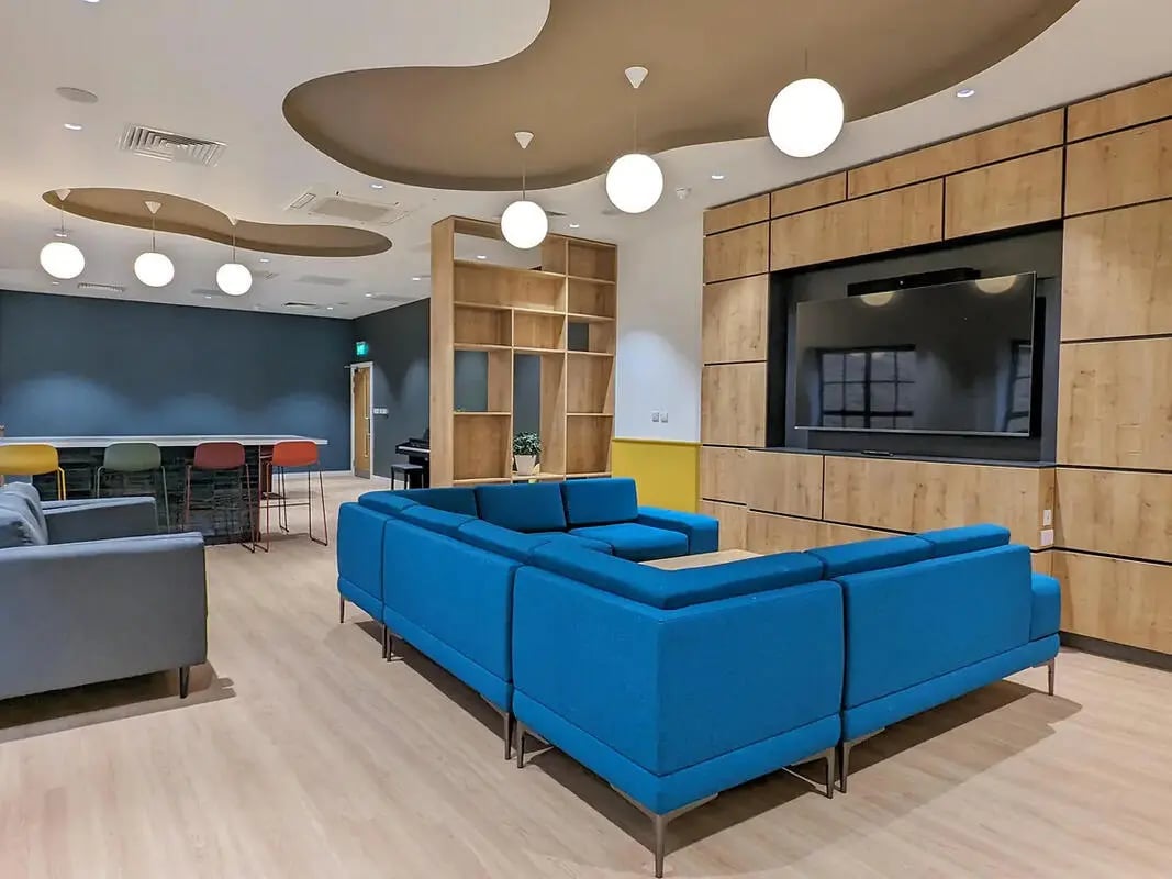 Blue sectional sofa lounge area with bar stools at Depot Point in London Student Accommodation