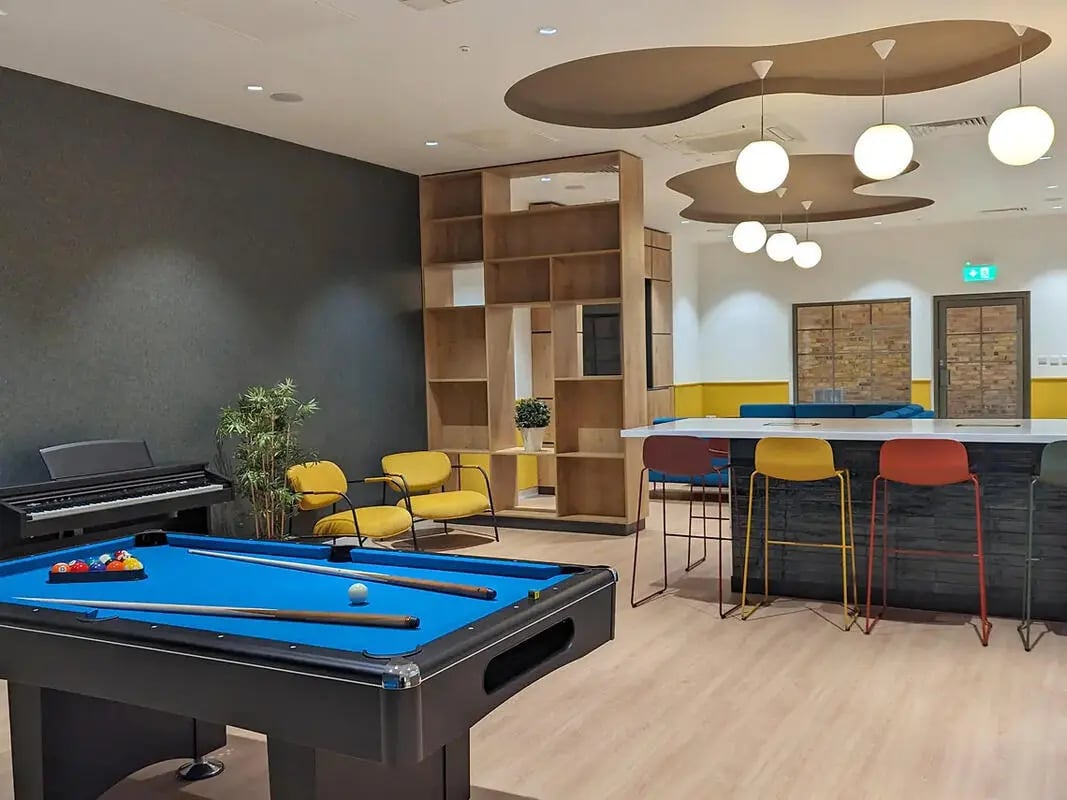 Pool table piano seating and bar stools common room at Depot Point in London Student Accommodation