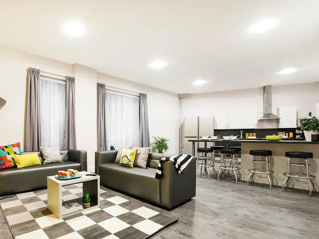 Two sofas coffee table and kitchen living room at Depot Point in London Student Accommodation