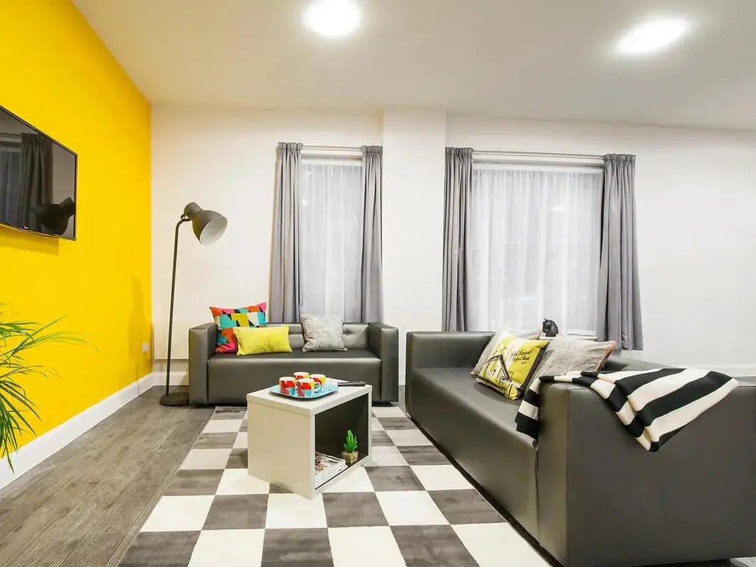 Modern living room with two grey sofas and checkered rug living room at Depot Point in London Student Accommodation