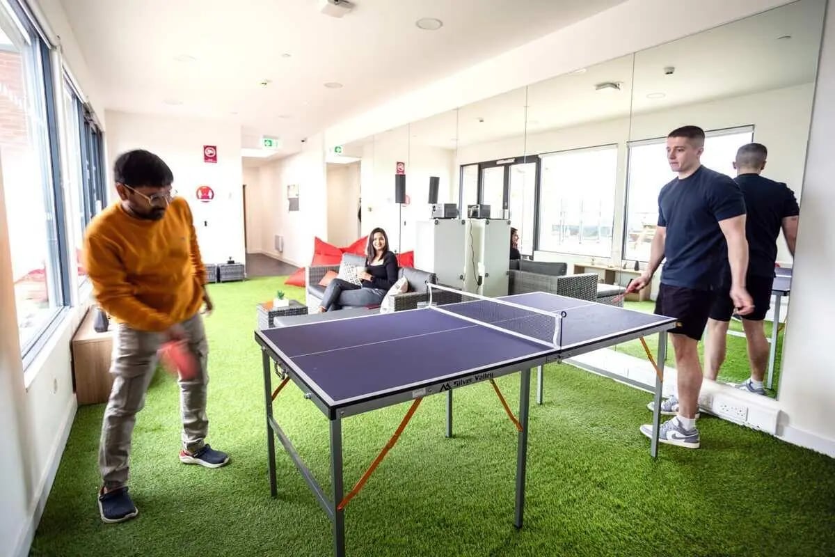 Ping pong table men and women playing recreation room at City Heights - Cardiff in Cardiff Student Accommodation