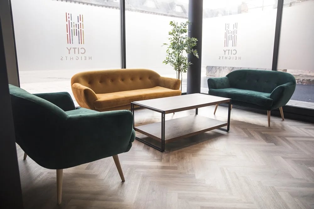 Green chairs gold sofa coffee table lounge area at City Heights - Cardiff in Cardiff Student Accommodation