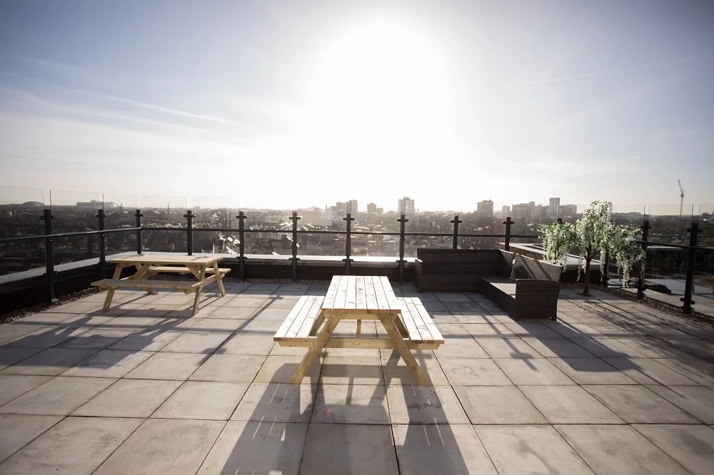 Picnic tables and lounge seating on rooftop terrace exterior at City Heights - Cardiff in Cardiff Student Accommodation