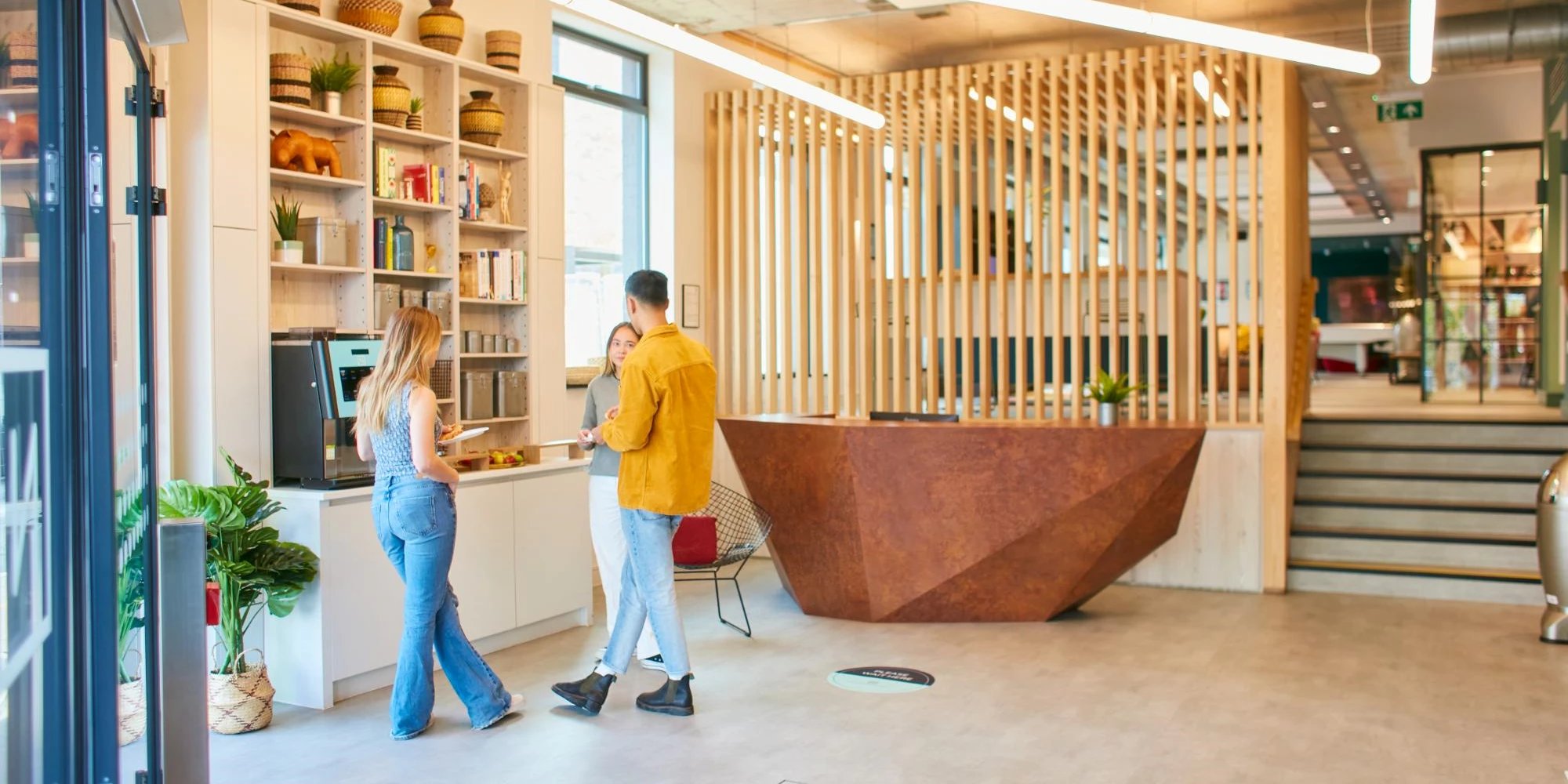 People talking by coffee machine and reception desk common area at Canvas Student - Quintana Gate in Exeter Student Accommodation