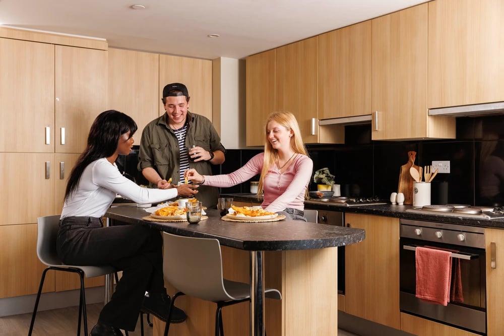 Students eating at a counter kitchen island kitchen at Greetham Street in Portsmouth Student Accommodation