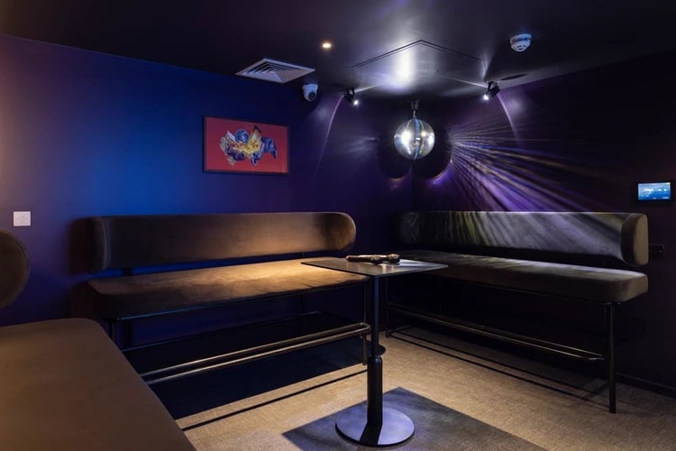 Karaoke area with couches disco ball and microphone living room at Stratford One in London Student Accommodation