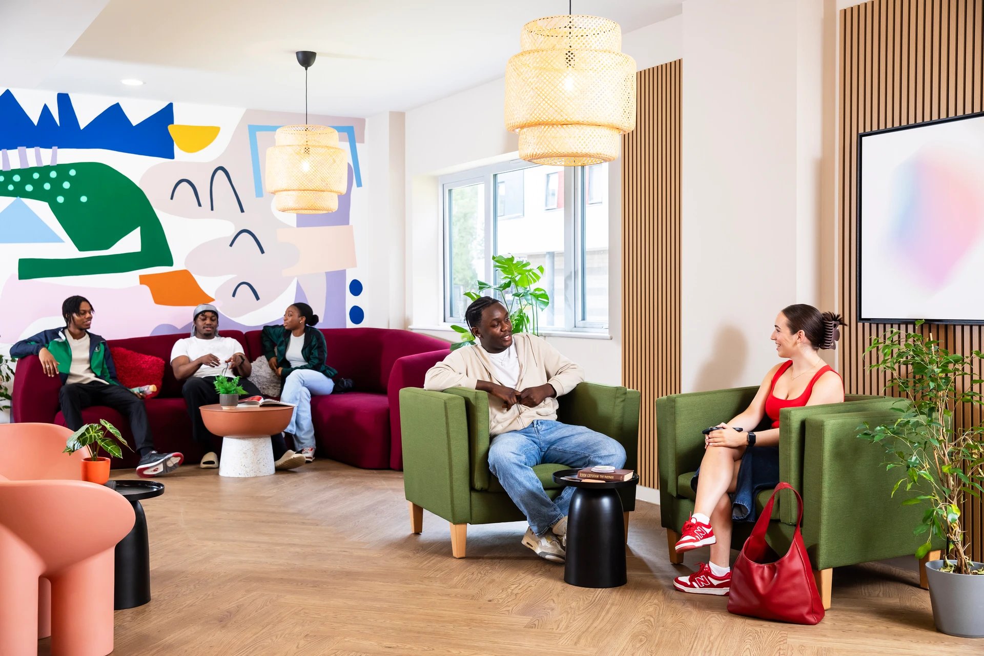 Students relaxing on couches and chairs living room at Pier Quays in Medway Student Accommodation