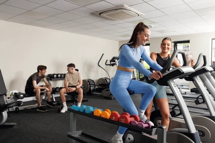Gym with people on bikes and weights at Quay Point in Newcastle Upon Tyne Student Accommodation