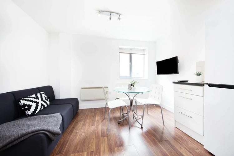 Sofa dining table chairs television white cabinets living kitchen at Grange Lane Apartments in Leicester Student Accommodation
