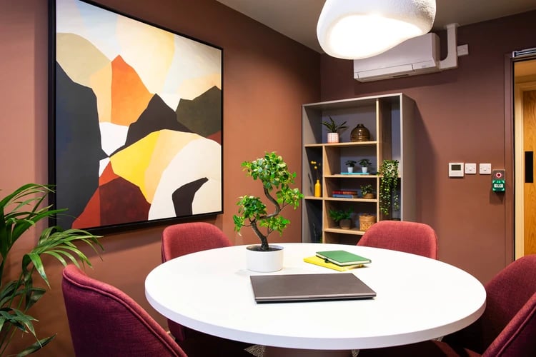 Round table four chairs artwork shelving study area at Station Court in London Student Accommodation