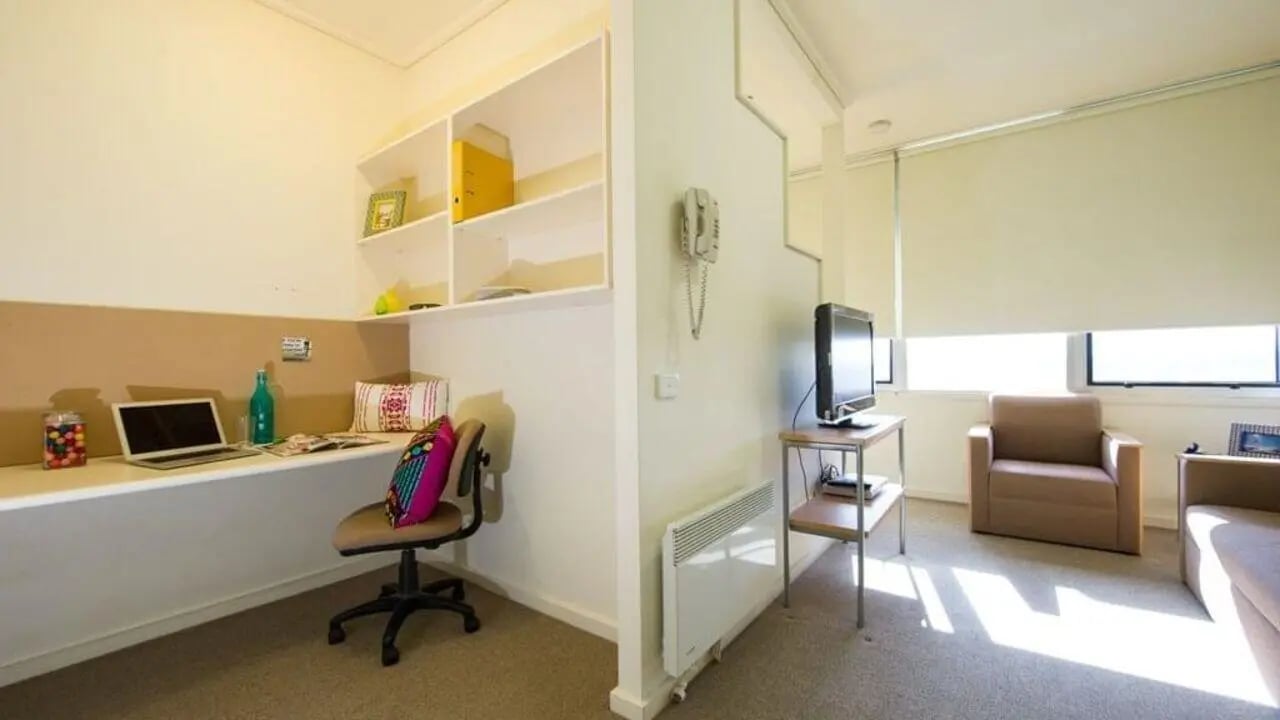 Desk chair laptop shelves and television living room at Student Living-590 Lygon in Melbourne Student Accommodation