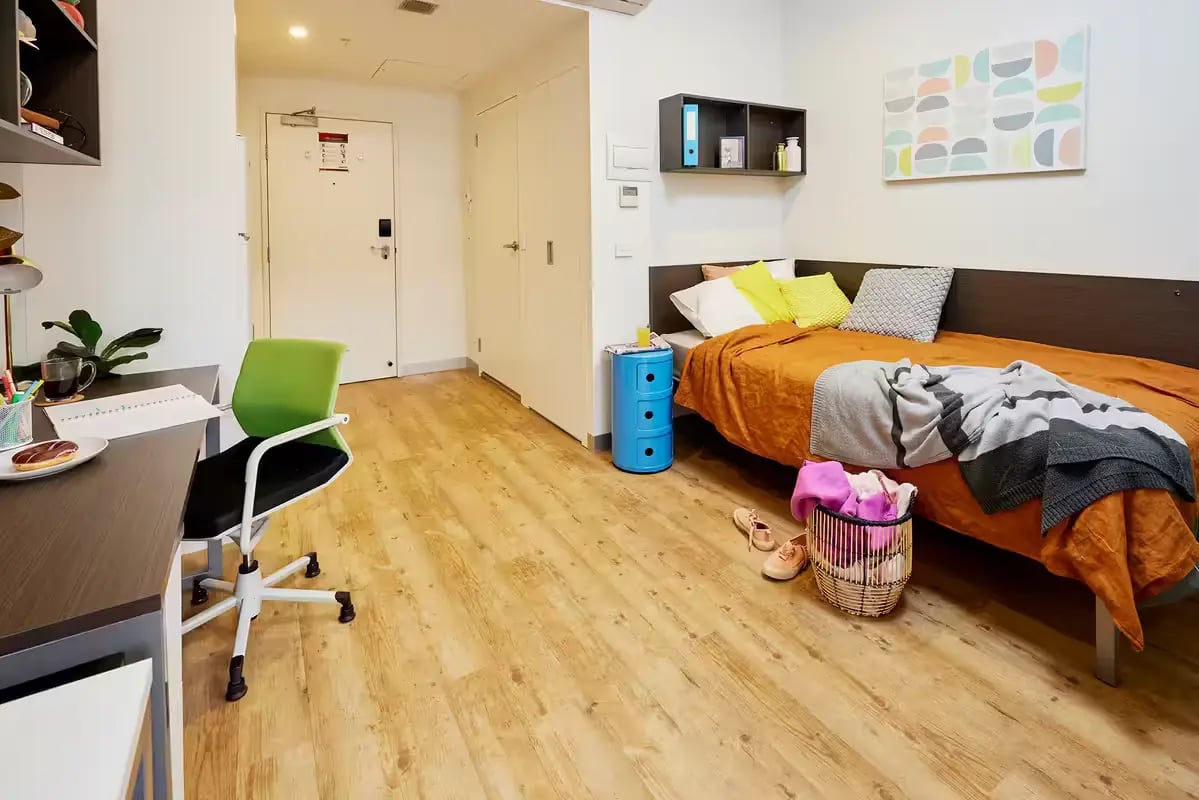 Desk chair bed blue cabinet basket bedroom at Scape Berkeley in Melbourne Student Accommodation