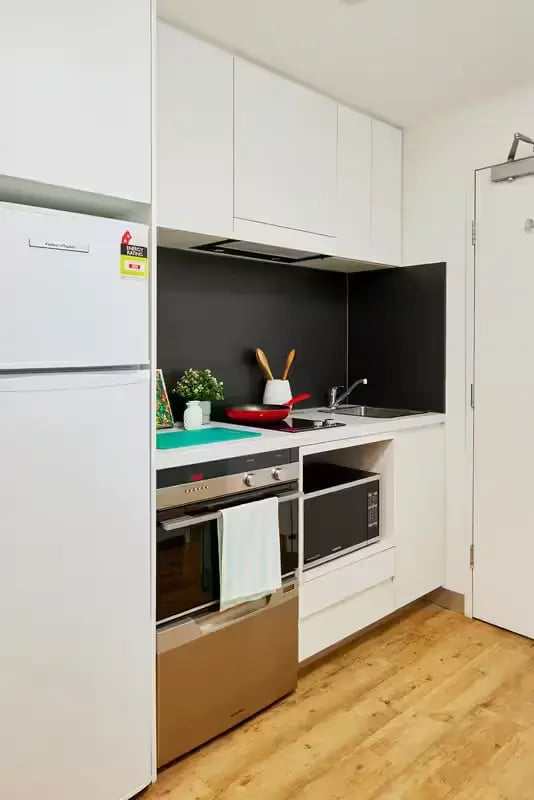 White fridge oven microwave small kitchen kitchen at Scape Berkeley in Melbourne Student Accommodation