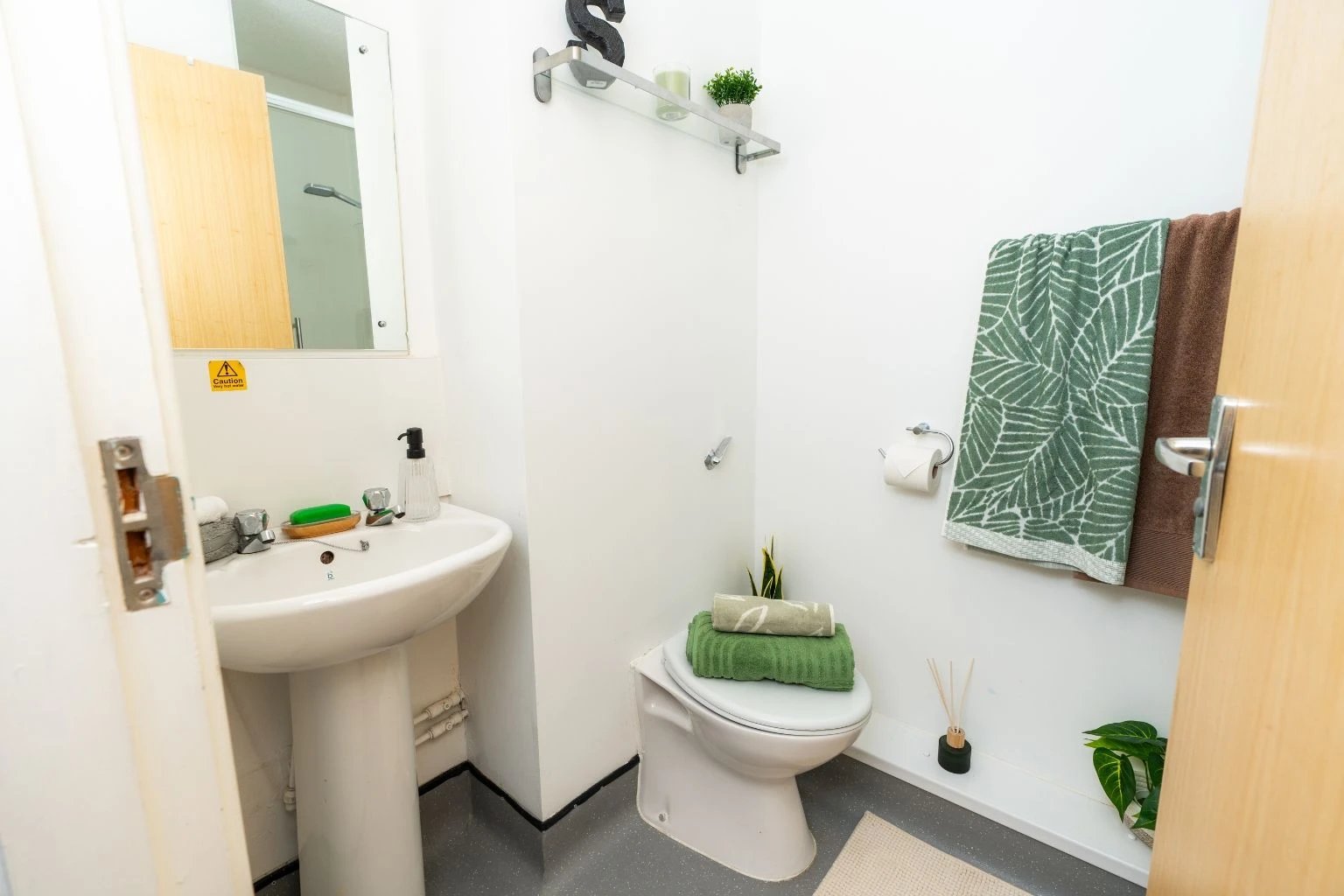 Sink toilet folded towels and shelving bathroom at Tramways - Salford in Salford Student Accommodation