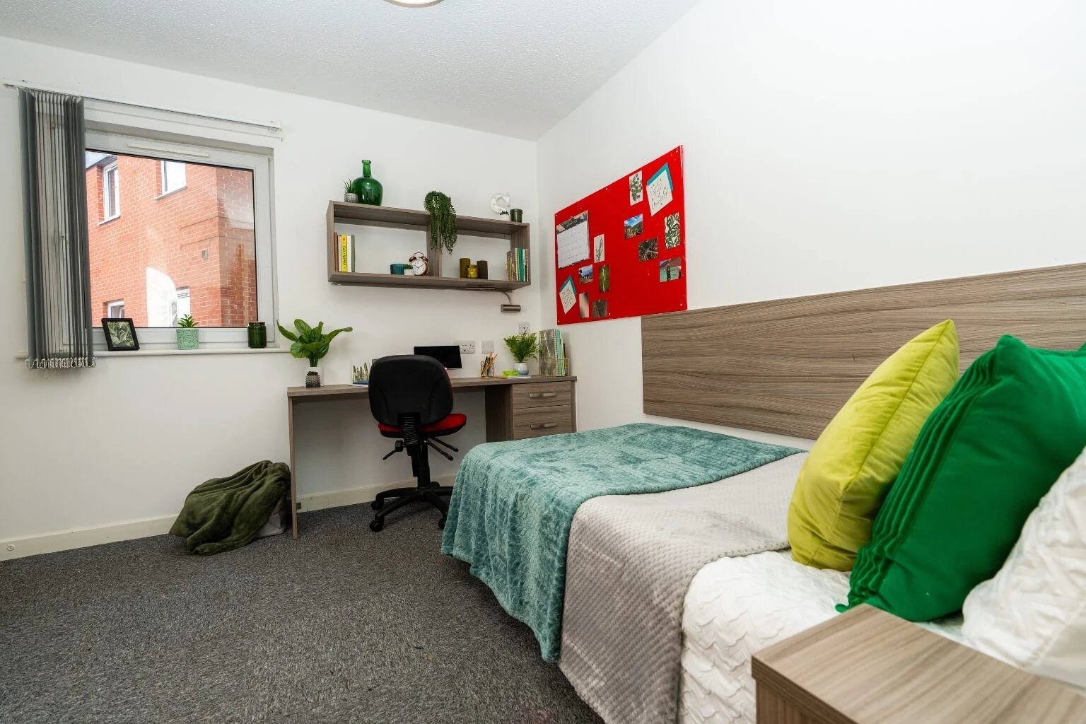 Bed desk chair shelves red noticeboard bedroom at Tramways - Salford in Salford Student Accommodation