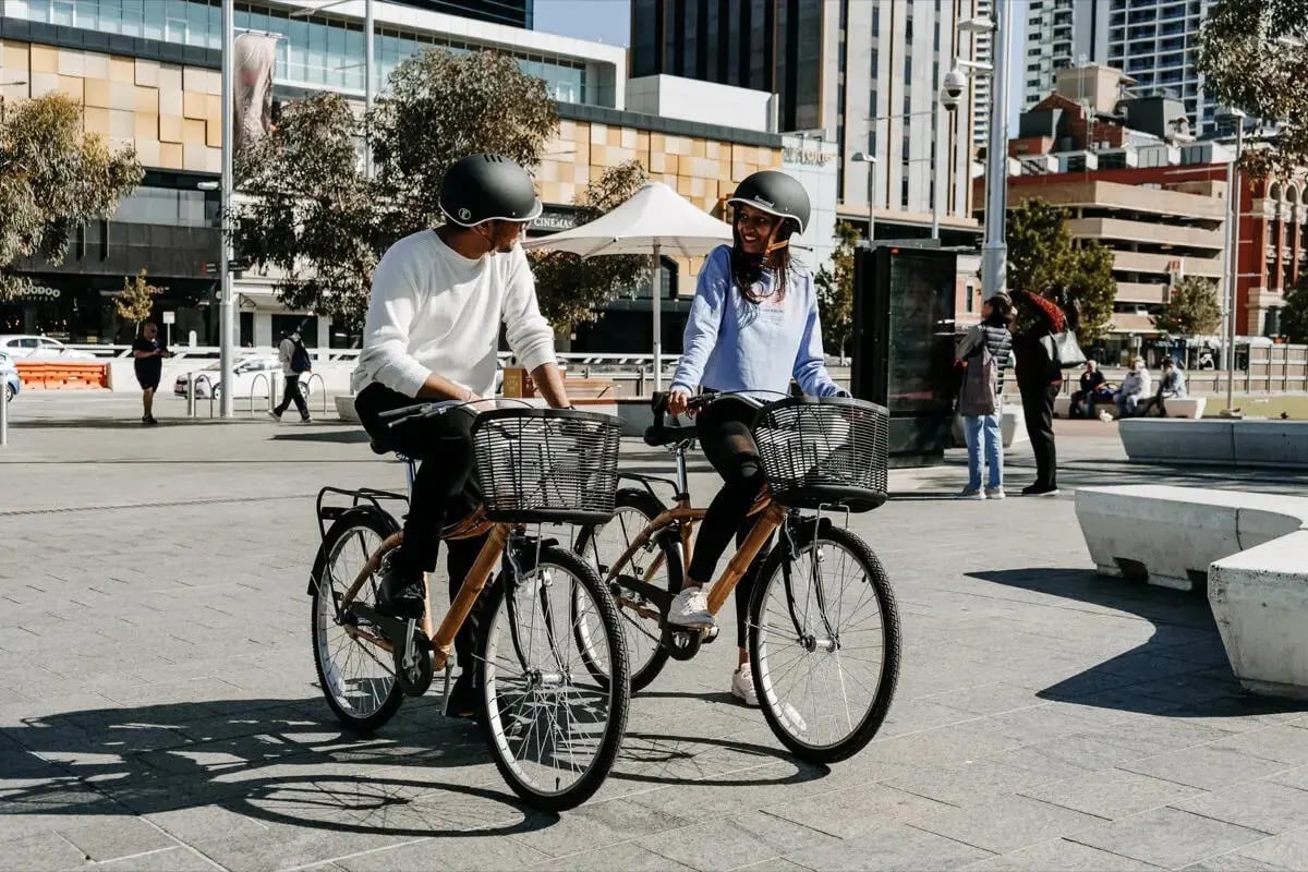 Two people cycling on city street exterior at Perth Central in Perth Student Accommodation