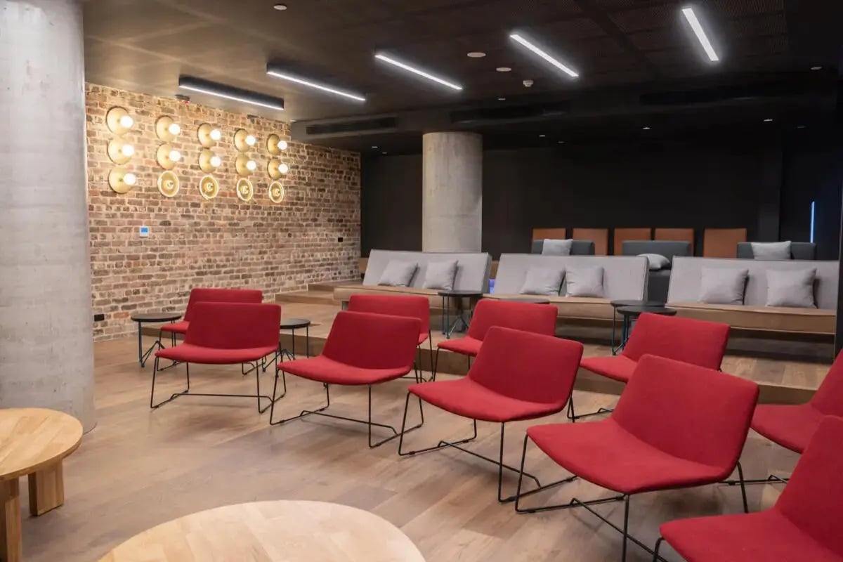 Red chairs brick wall lounge seating living room at Perth Central in Perth Student Accommodation