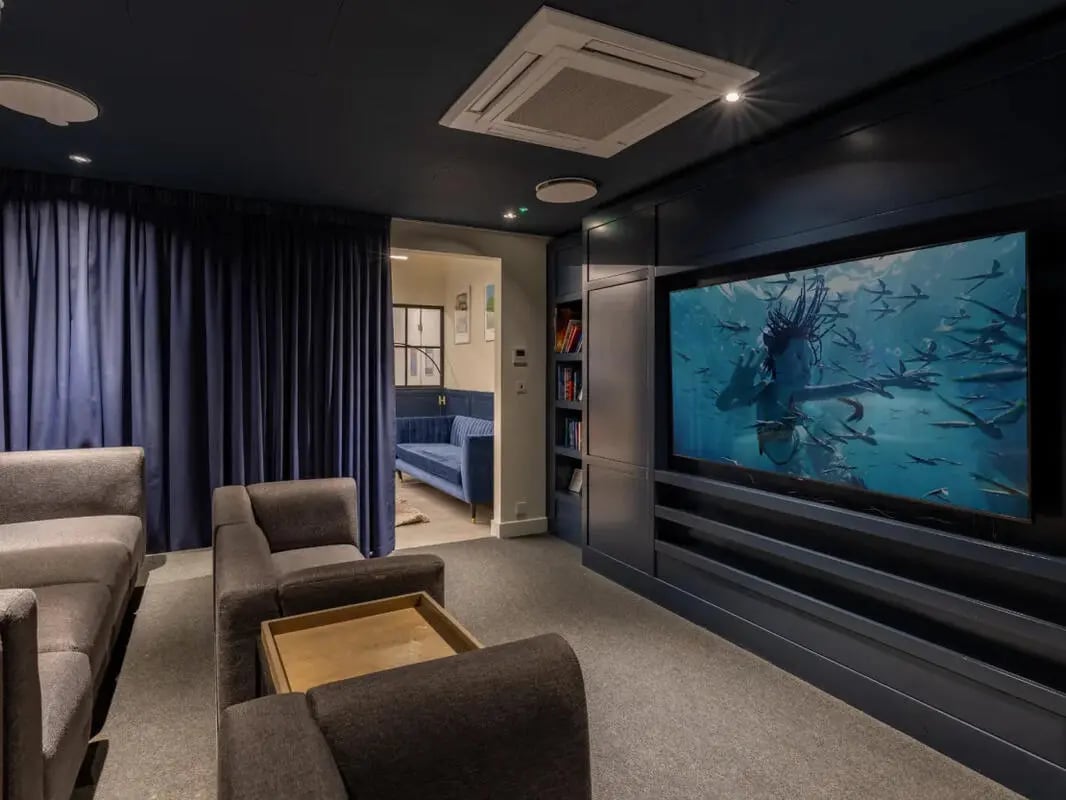 Sofas television bookshelves blue curtains living room at Great Court in London Student Accommodation