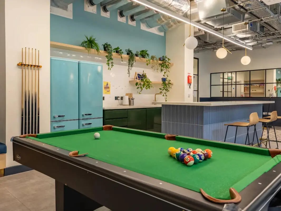 Pool table cues fridge kitchen seating area playing area at Great Court in London Student Accommodation