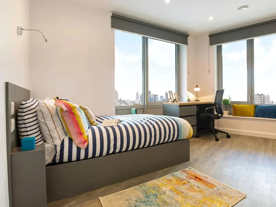 Bed desk chair and windows student bedroom at Great Court in London Student Accommodation