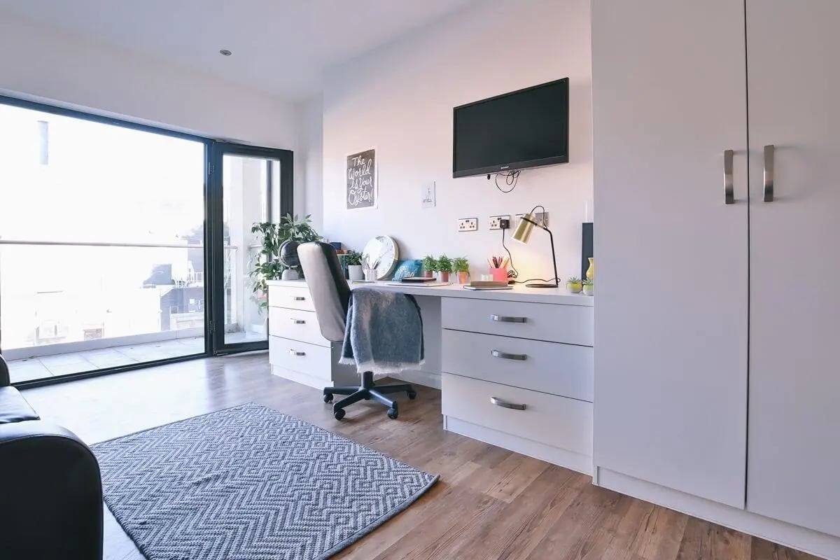 Desk chair plants television white drawers study area at 136 New Walk Leicester in Leicester Student Accommodation